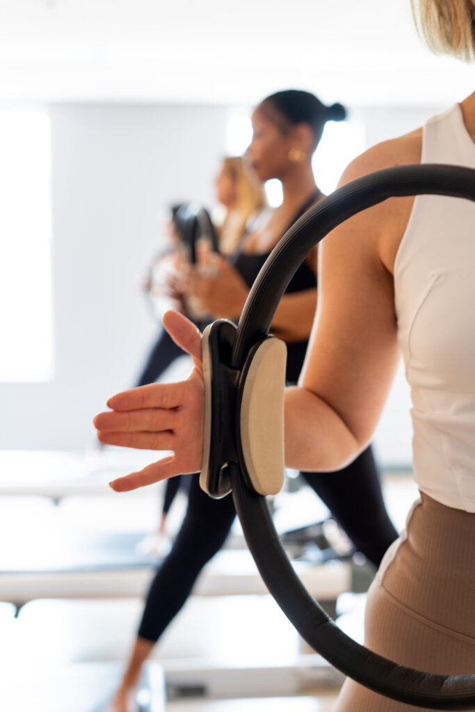 Clients holding a magic circle during a Naperville Pilates class at Shyft Pilates.